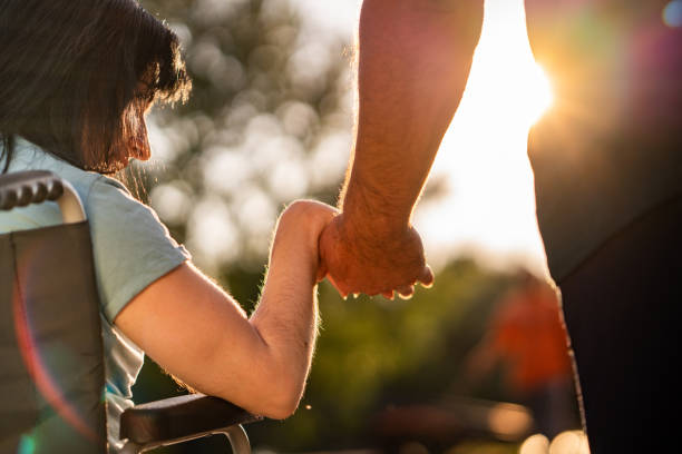 Close-up of a disabled woman holding the hand of a man